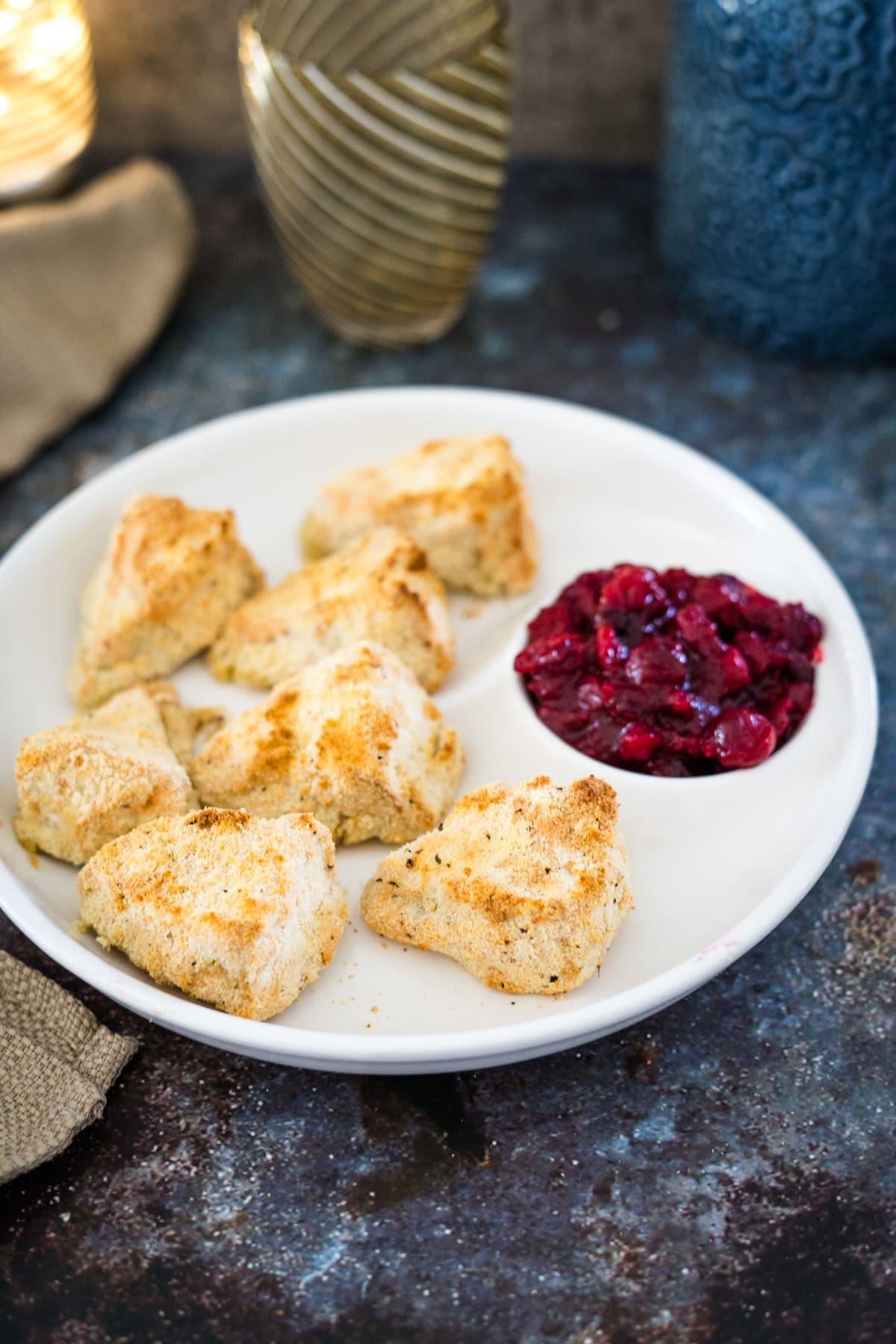 Cranberry scones on a plate with cranberry sauce.