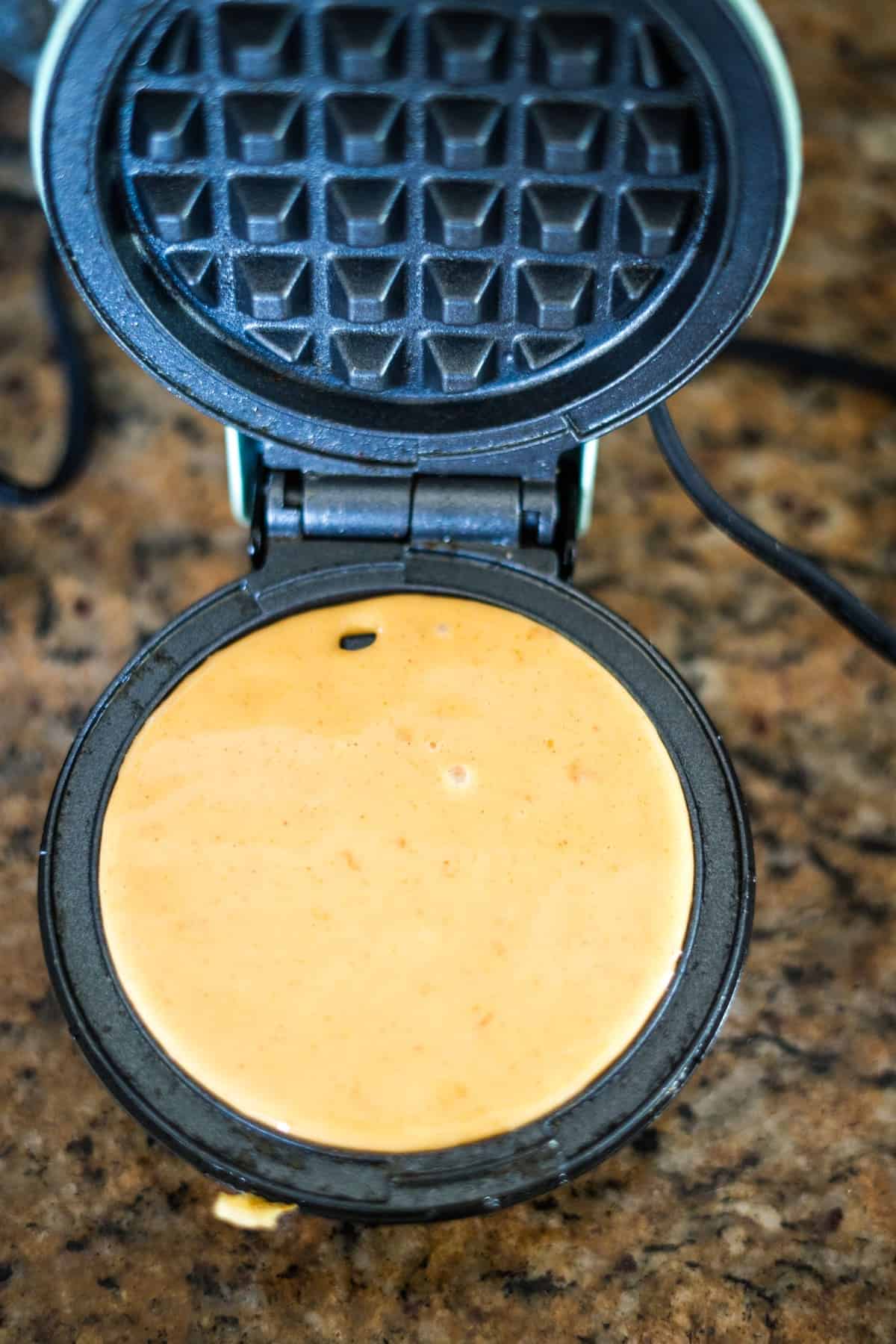 A peanut butter waffle maker with a waffle in it.
