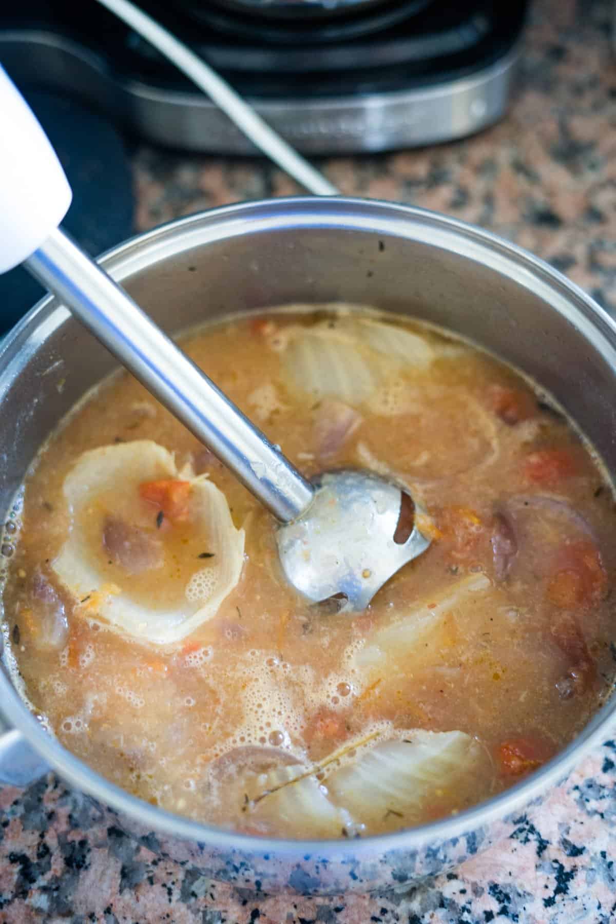 A spoon is being used to stir a pot of soup.