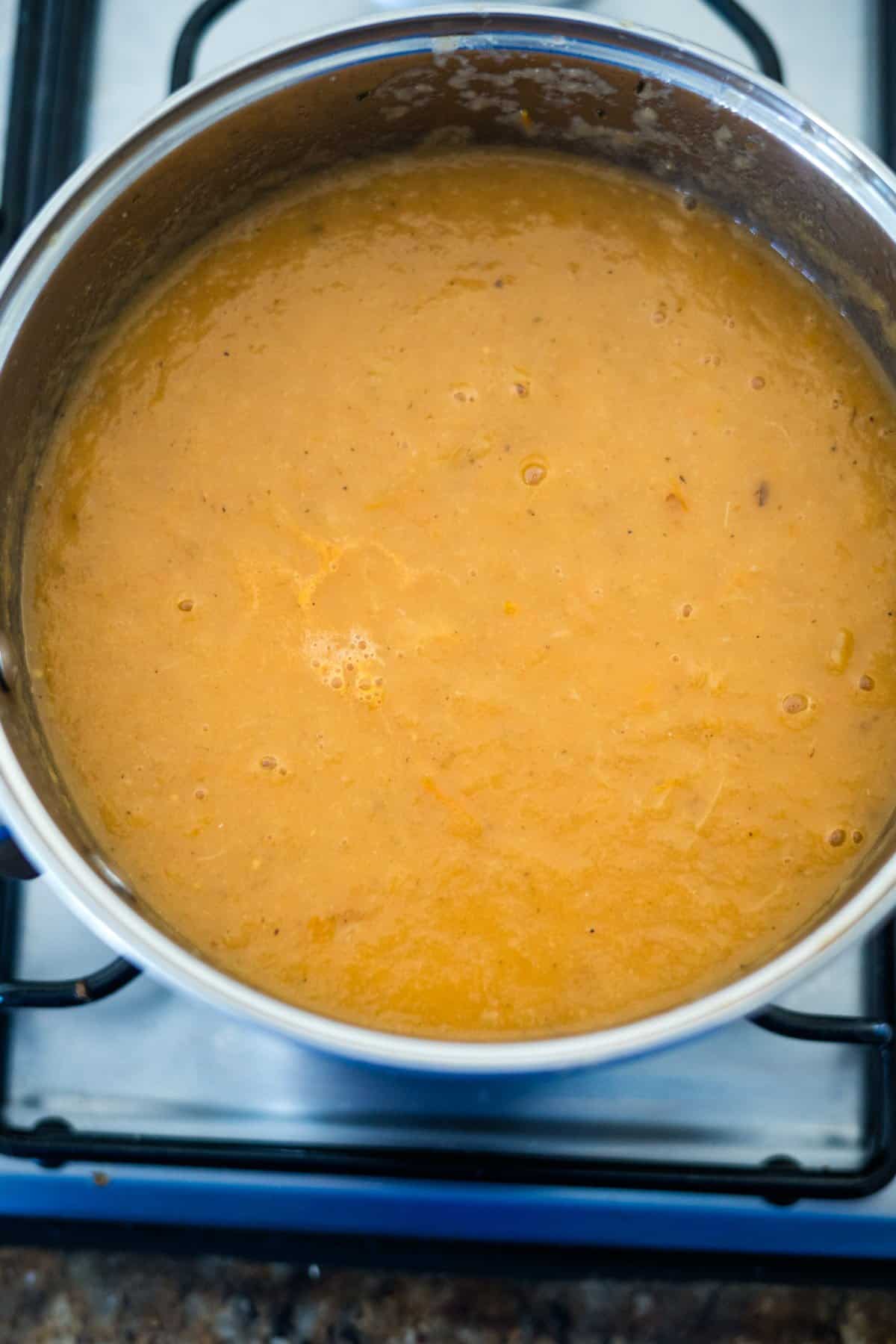 A pot of soup on a stove top.