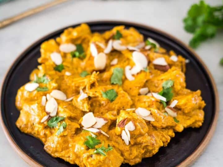 Chicken tikka masala on a plate with almonds.