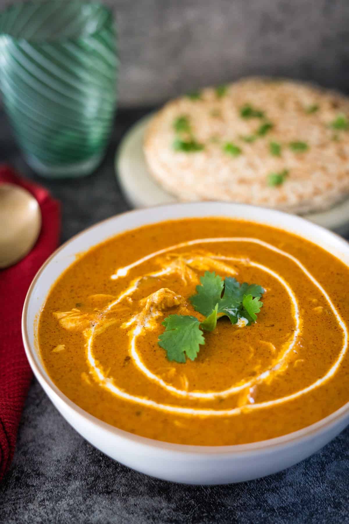 A steaming bowl of chicken tikka masala soup on a table.