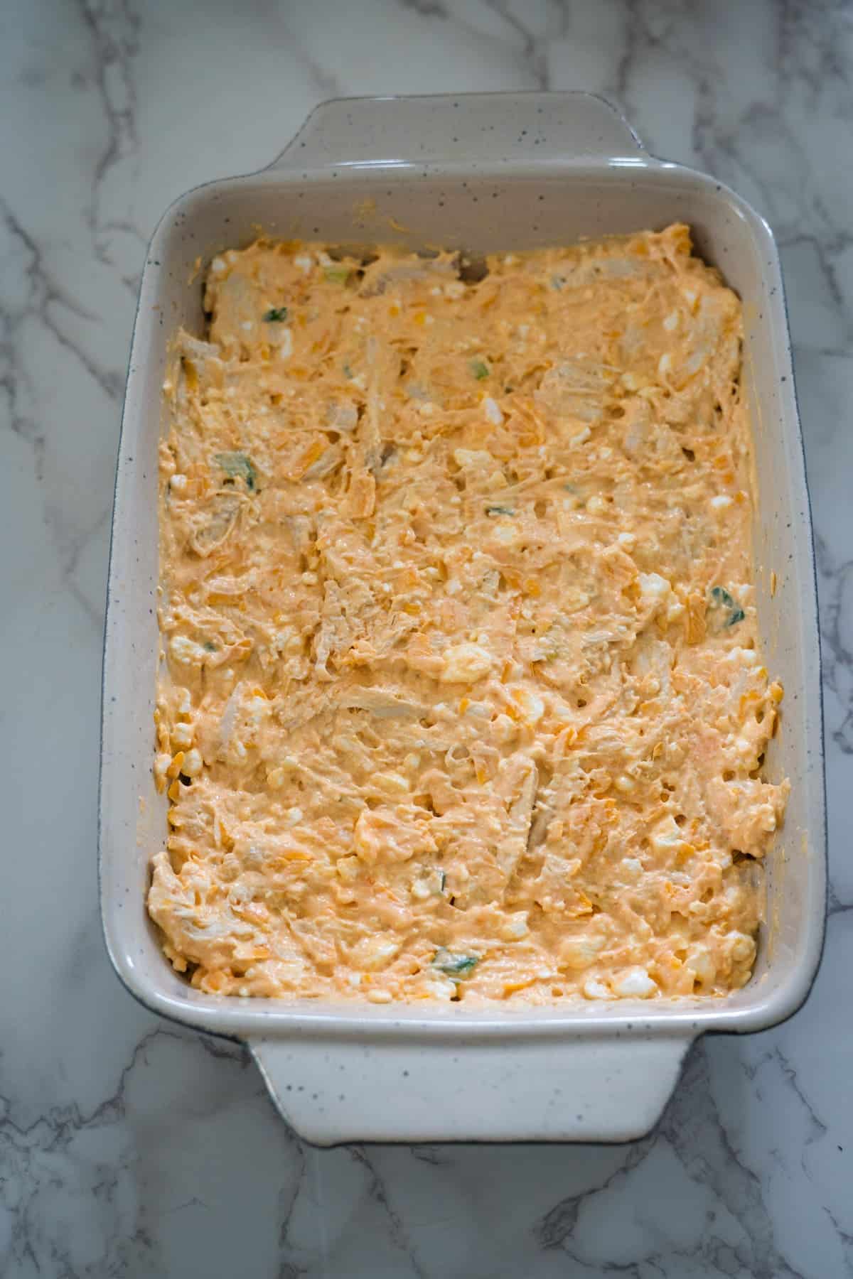 Buffalo chicken dip, made with cottage cheese, served in a white baking dish.