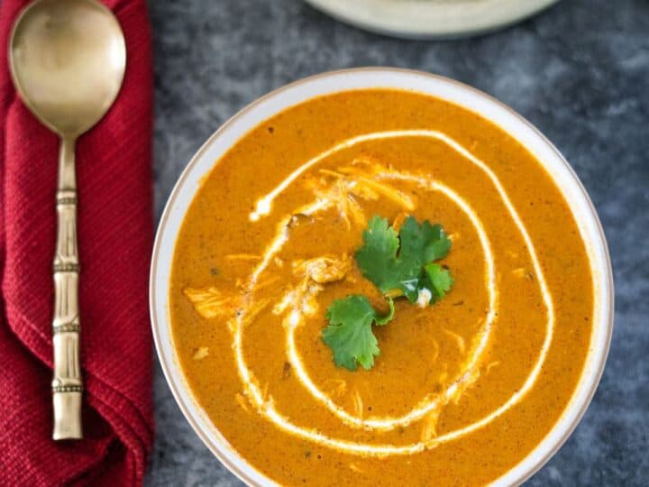 A bowl of soup with a spoon and a napkin.