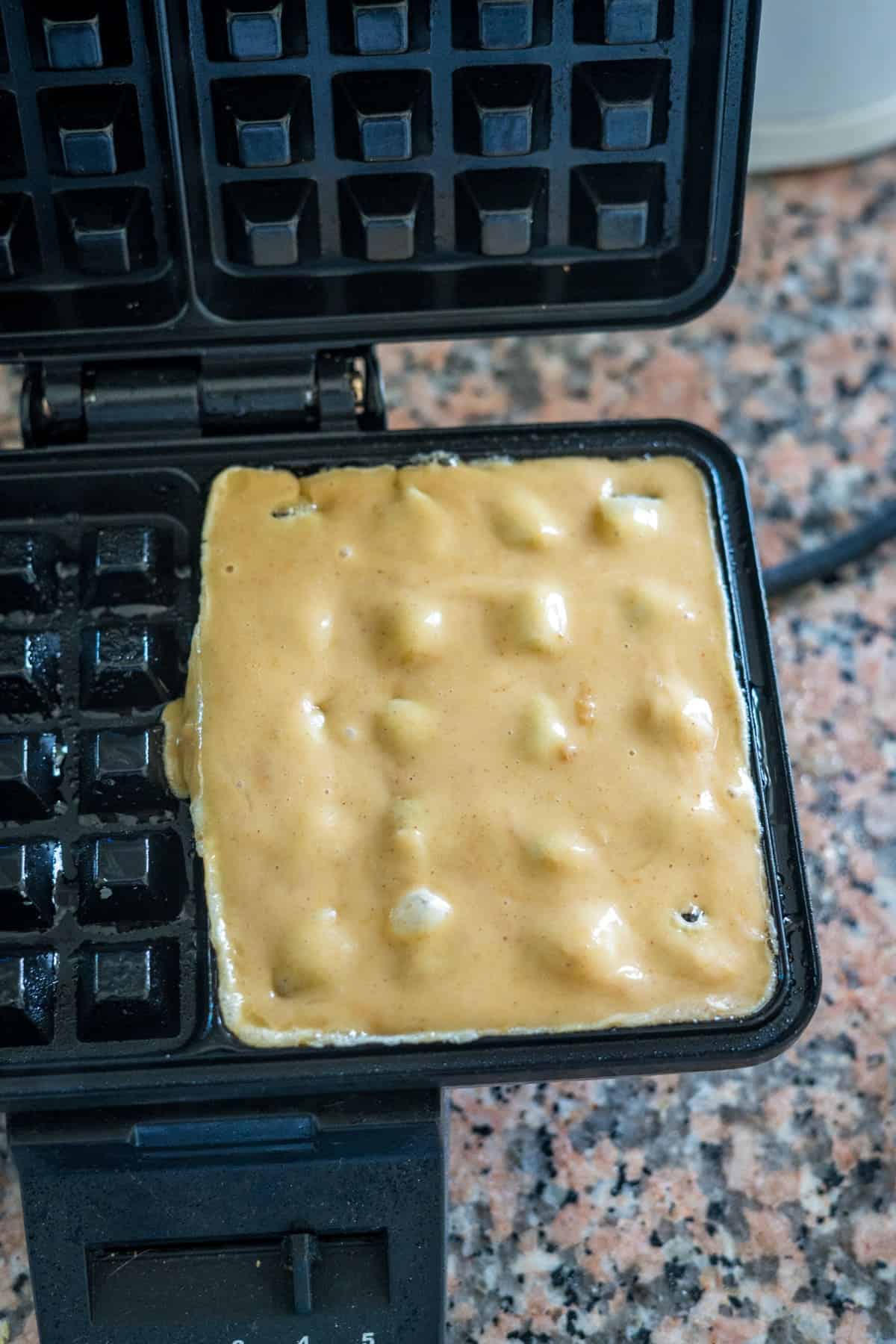 A peanut butter waffle maker with a waffle in it.