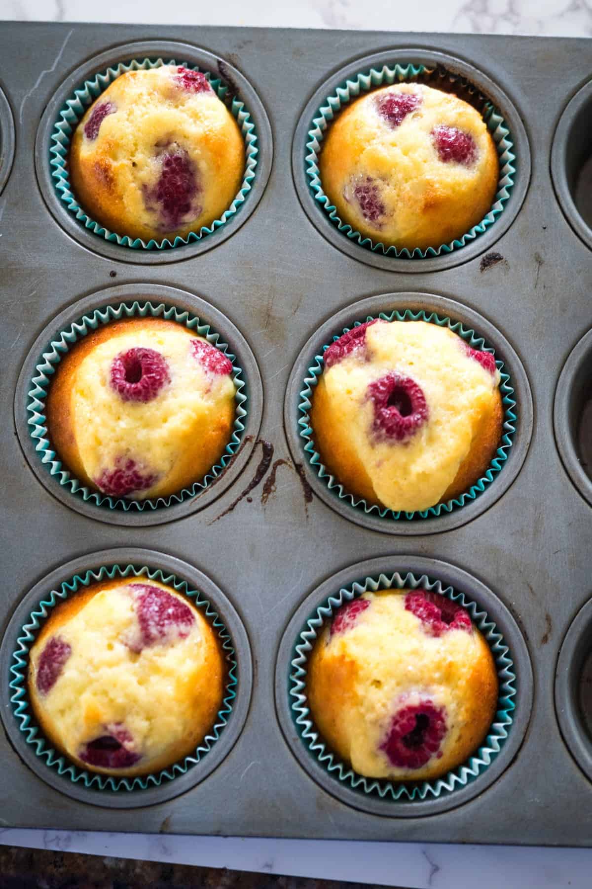 Keto raspberry muffins baked in a muffin tin.