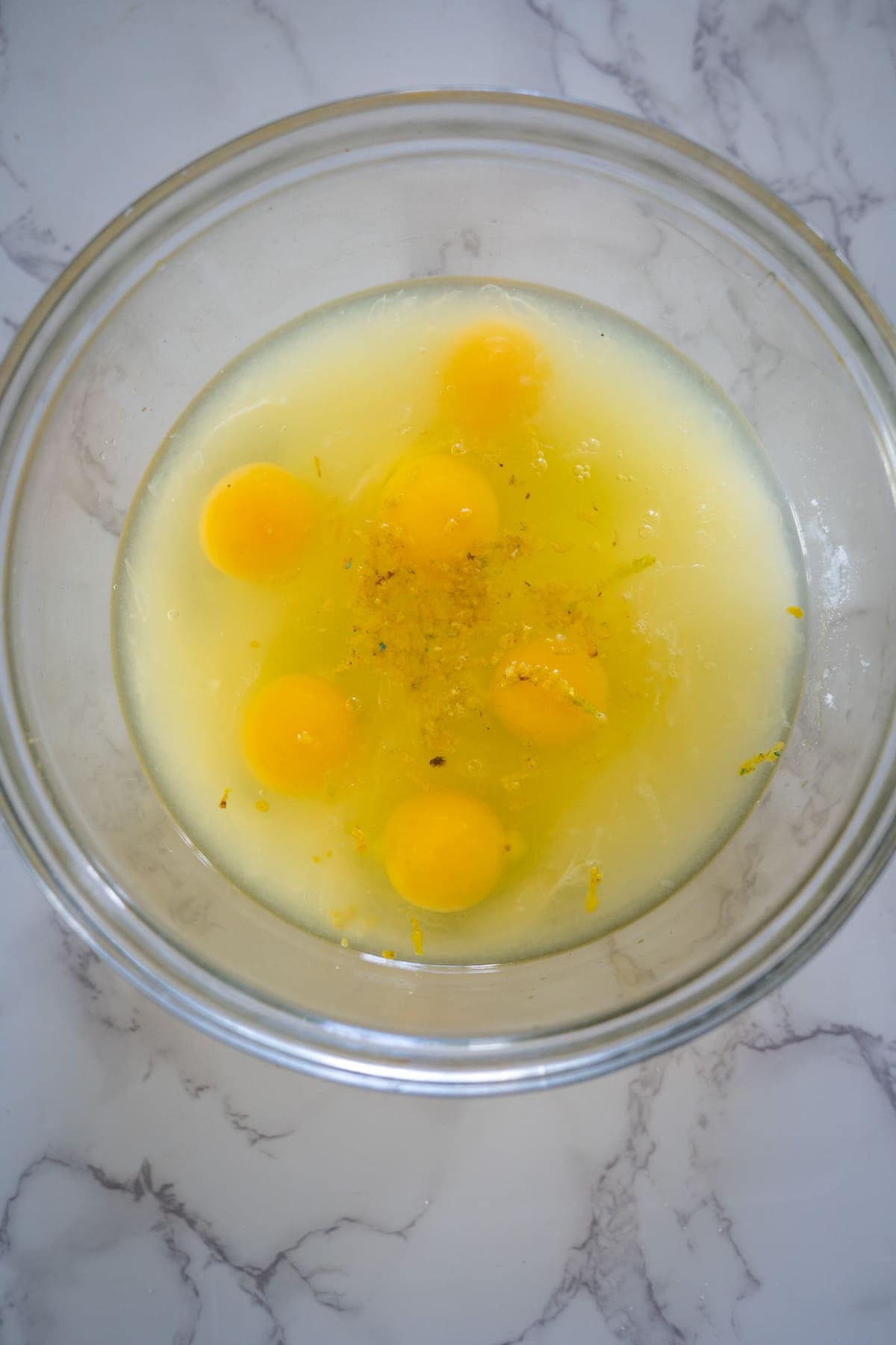 Eggs in a bowl on a marble countertop.