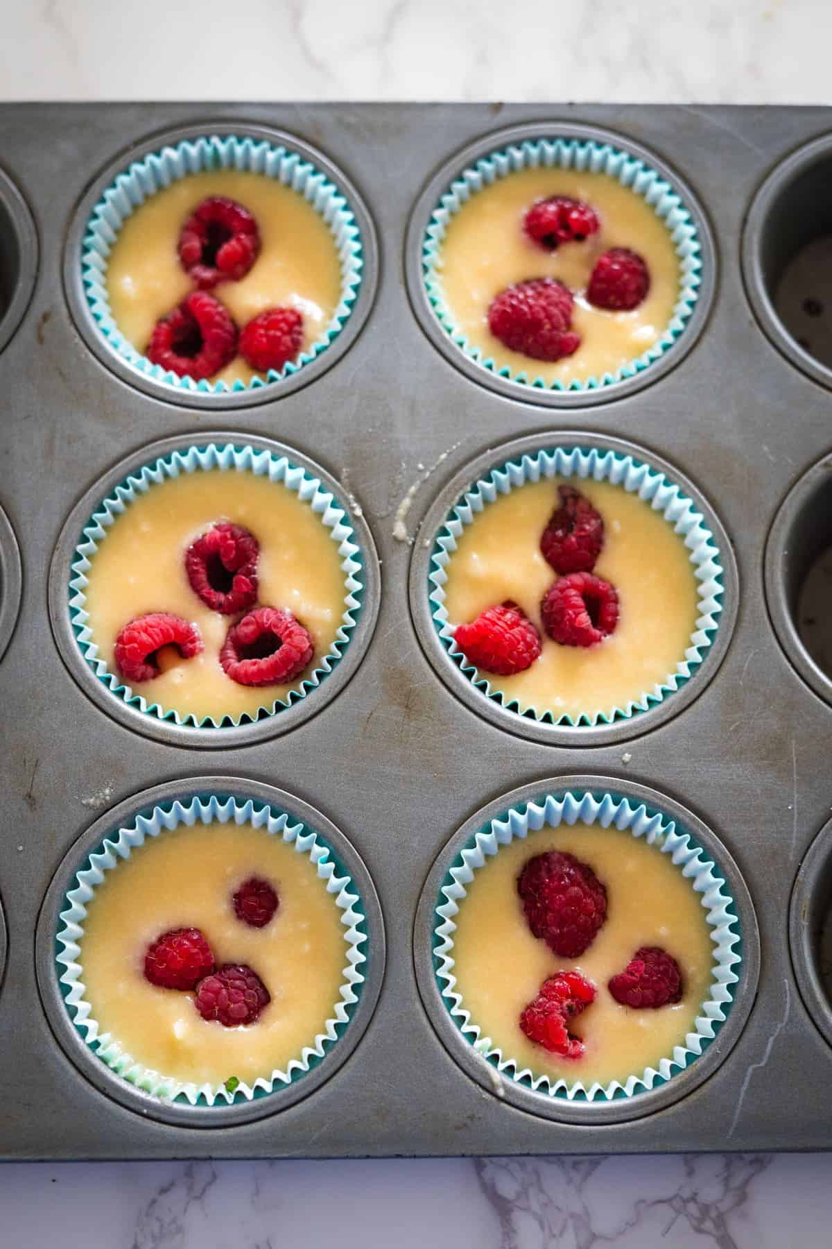 A muffin tin filled with keto raspberry muffins.