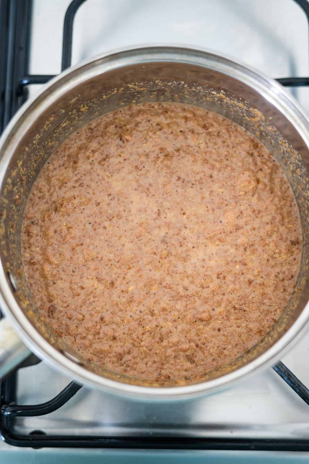 A pot of simmering flaxseed porridge on a stove top.