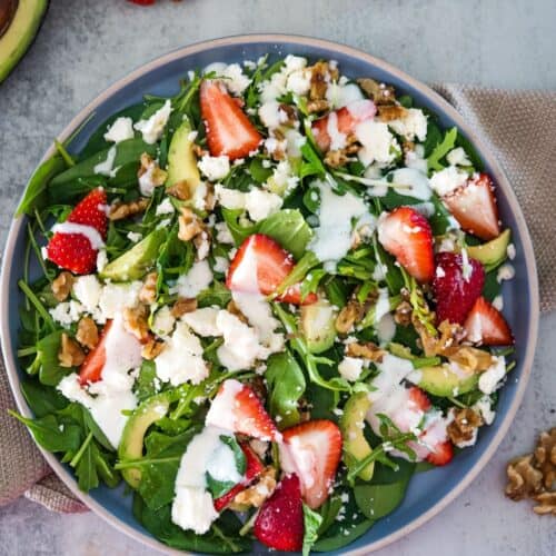 Fresh strawberry spinach salad with walnuts and feta cheese.