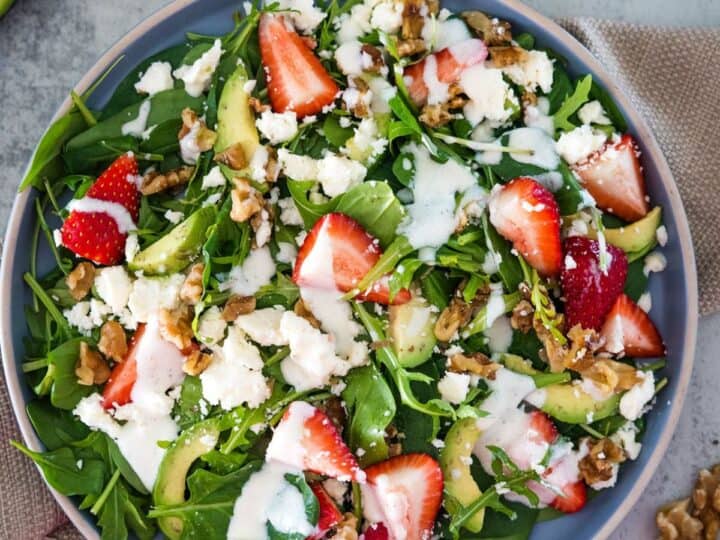 Fresh strawberry spinach salad with walnuts and feta cheese.