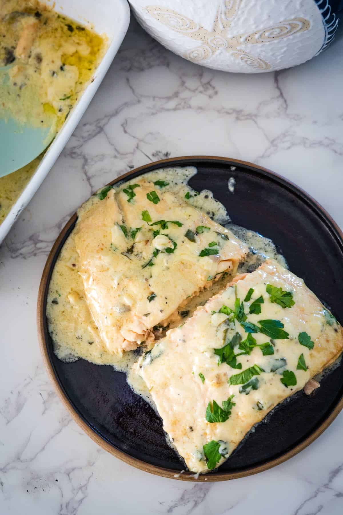 Salmon in lemon creamy sauce on a plate.