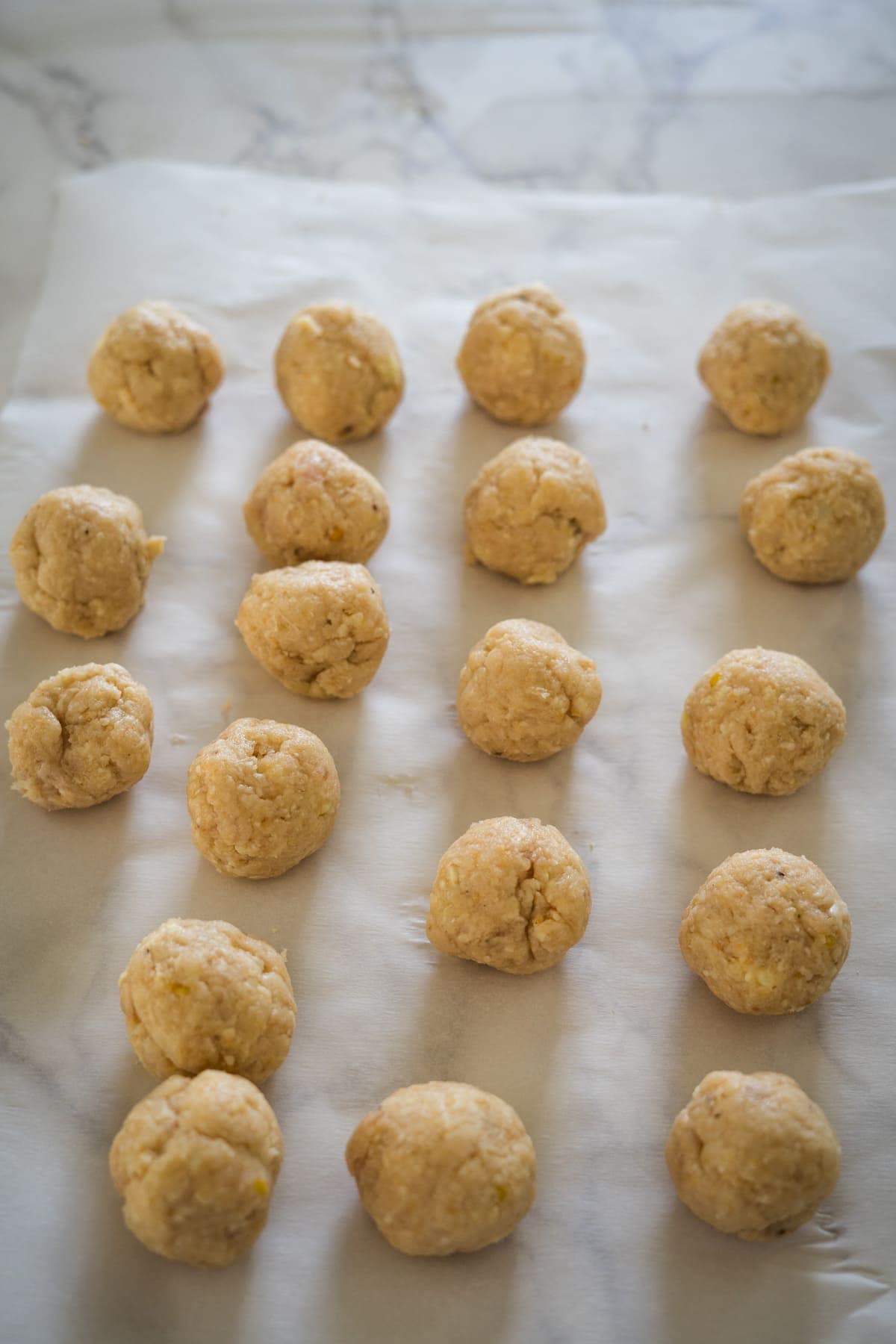 Chicken piccata meatballs neatly arranged on parchment paper.