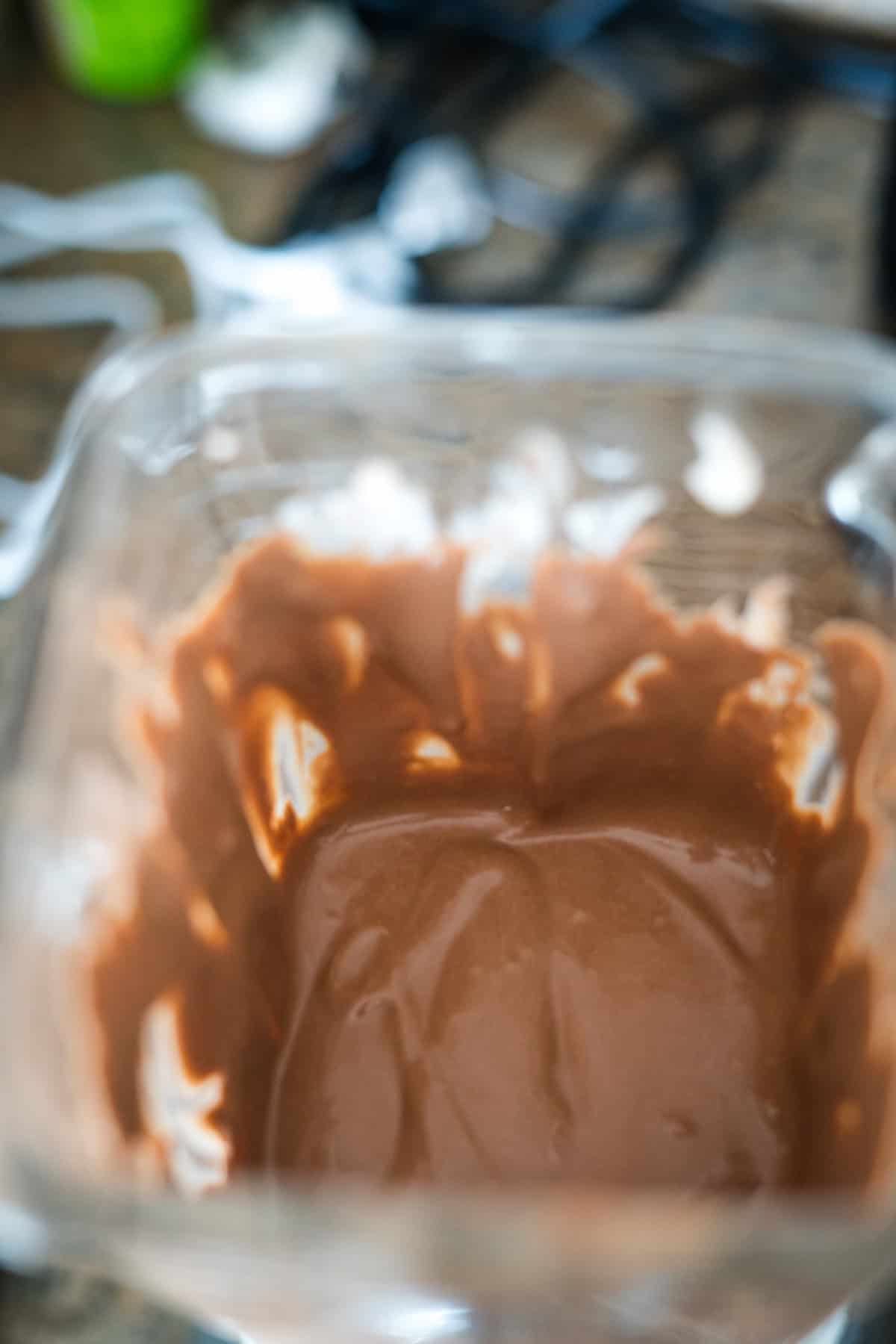 Close-up of a bowl containing partially melted chocolate, with some chocolate smeared along the sides.