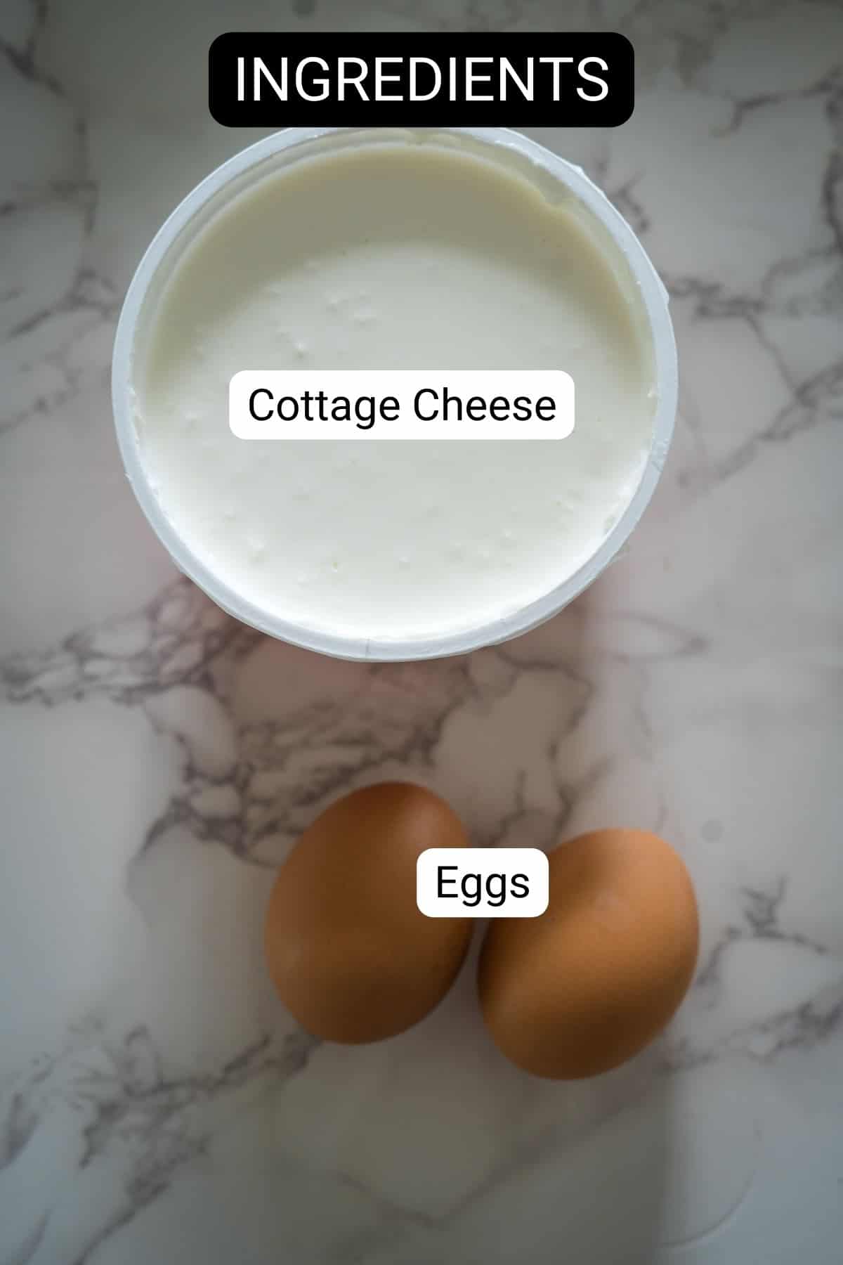 A container of cottage cheese and two brown eggs placed on a marbled surface with labeled tags indicating the ingredients.