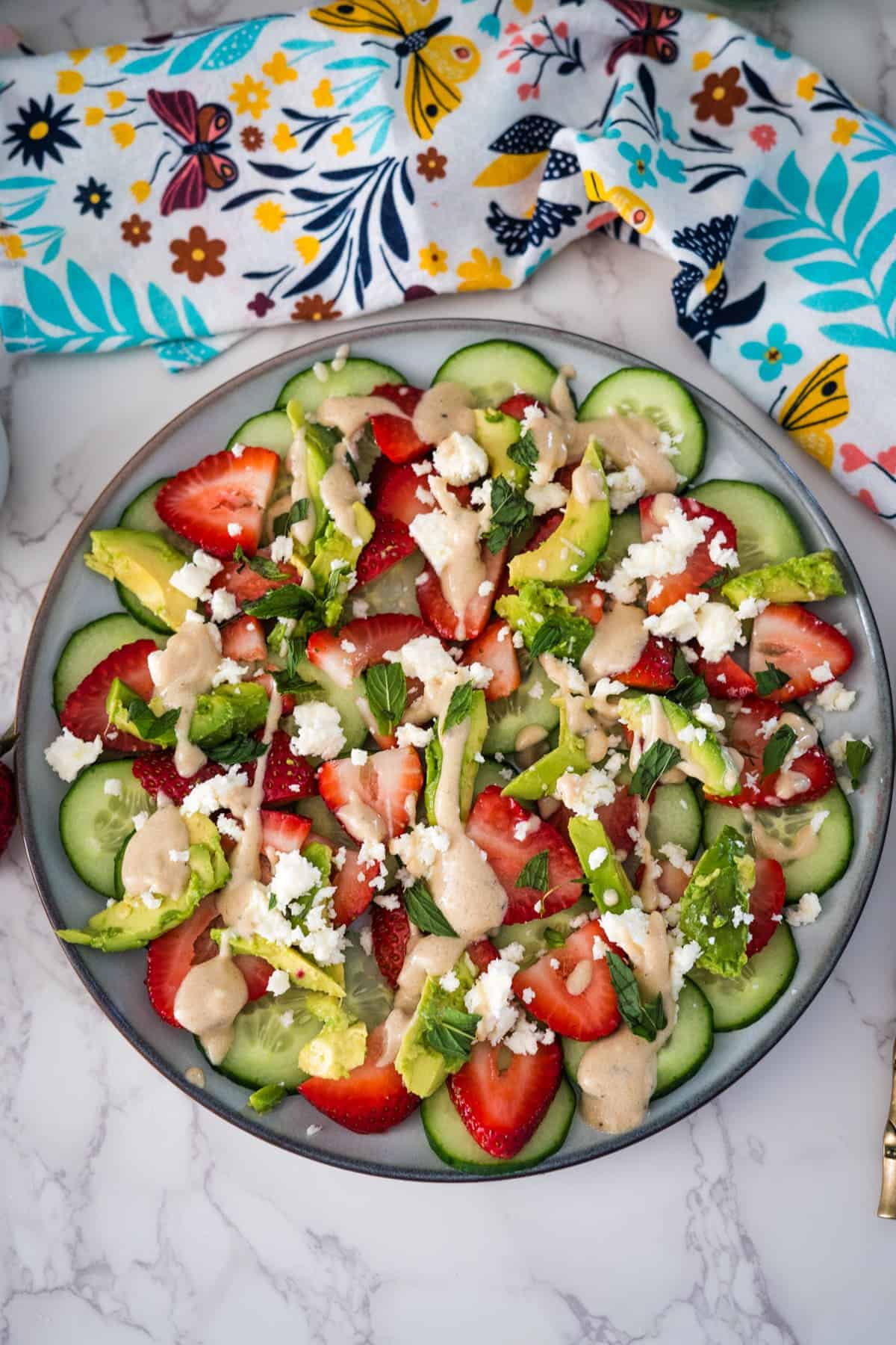 A plate of cucumber and strawberry salad.