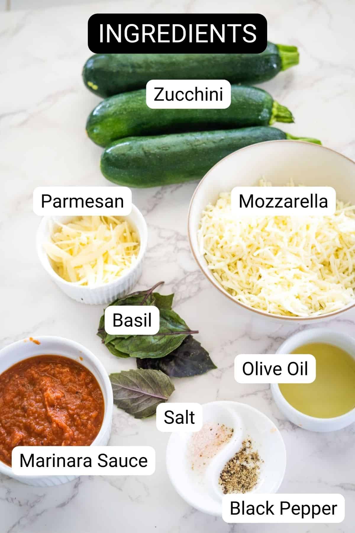 Image of ingredients on a marble surface: zucchinis, shredded mozzarella, grated parmesan, basil leaves, marinara sauce, olive oil, salt, and black pepper. Labels identifying each item are present.