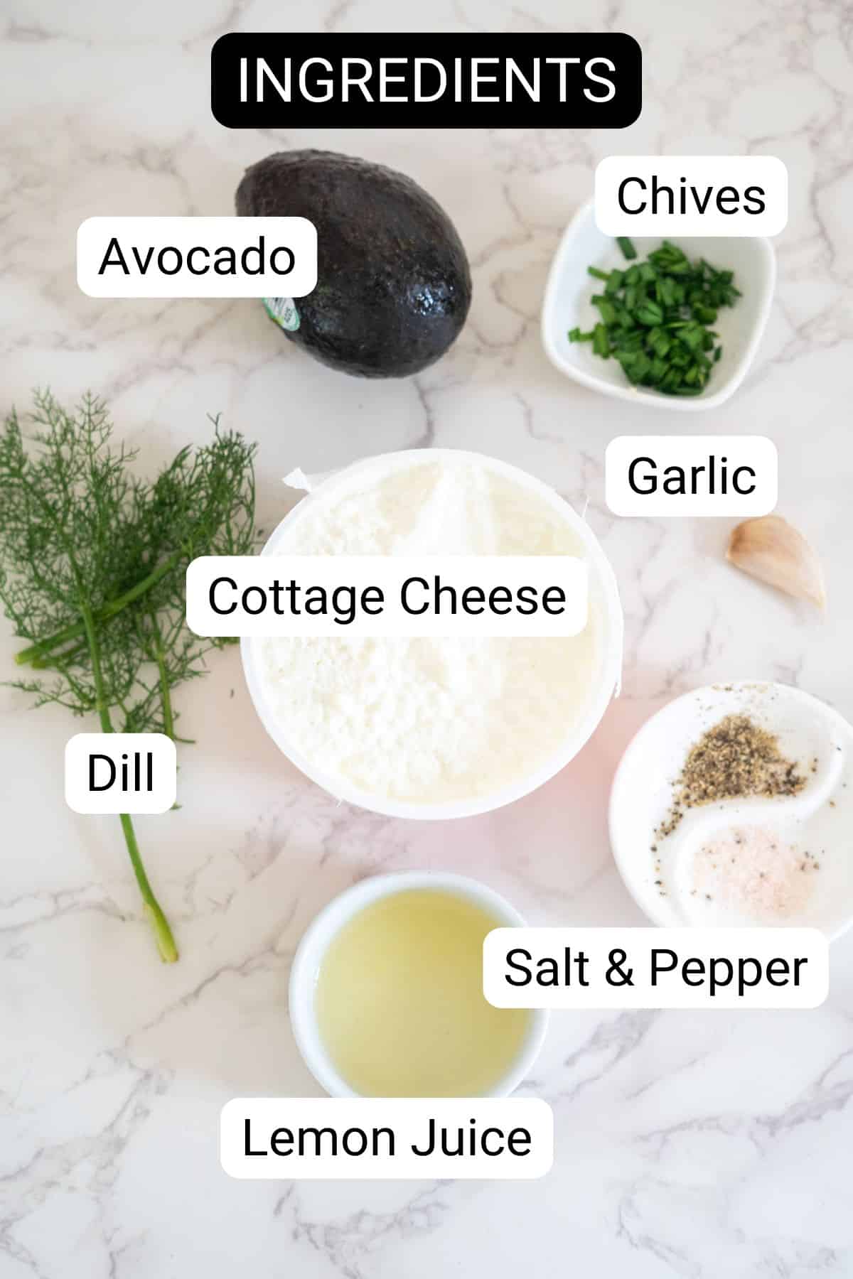 A labeled image of ingredients for a recipe, including an avocado, chives, garlic, cottage cheese, dill, salt and pepper, and lemon juice, arranged on a marble surface.