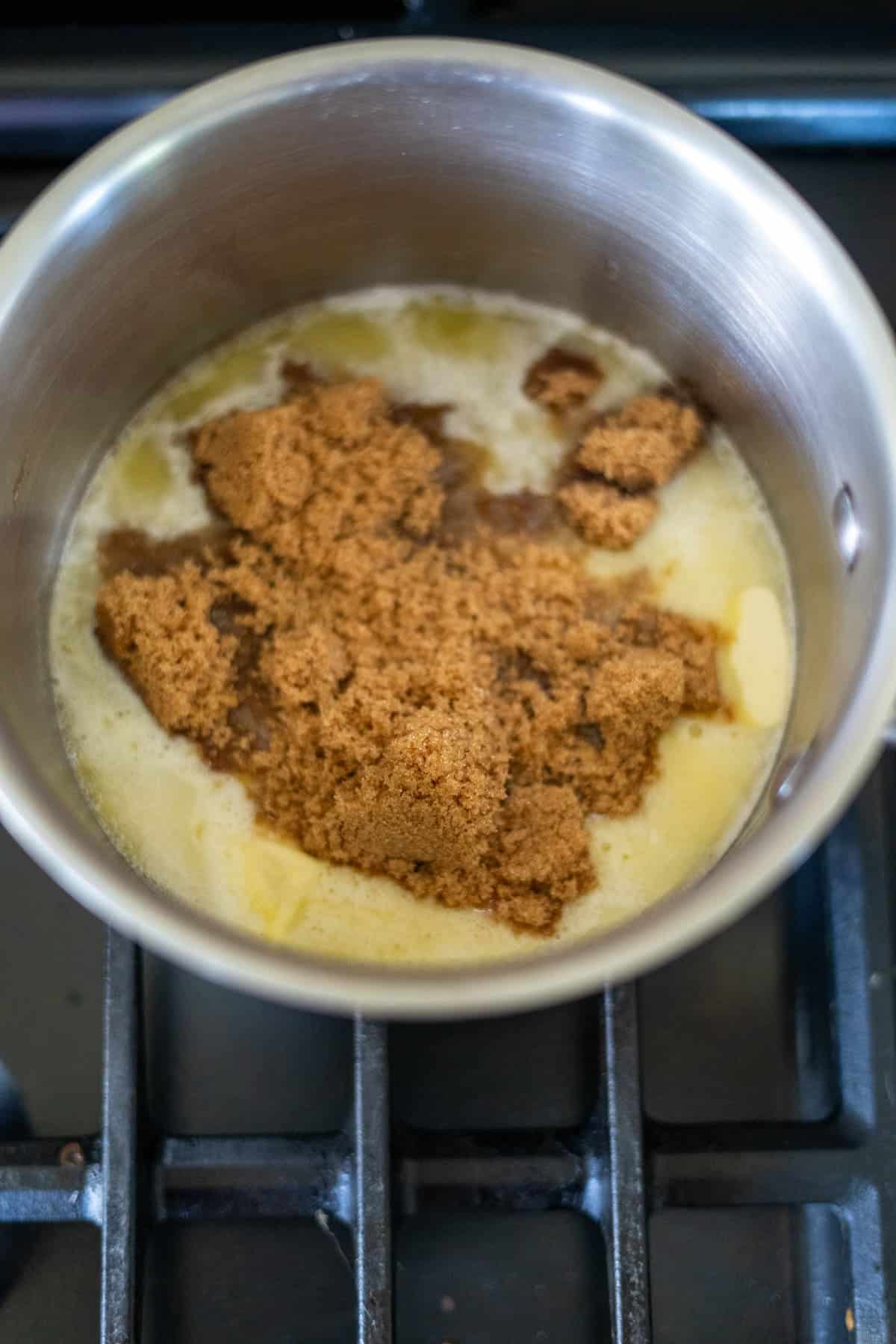 Keto peanut butter fudge dreams begin with brown sugar melting in butter inside a saucepan on the stove, creating a luscious base for decadent indulgence.